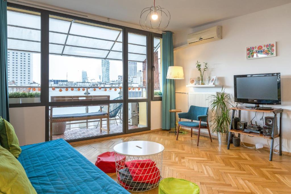 salon z kanapą i dużym oknem w obiekcie WSTApartments Sunset View Krucza 46 w Warszawie