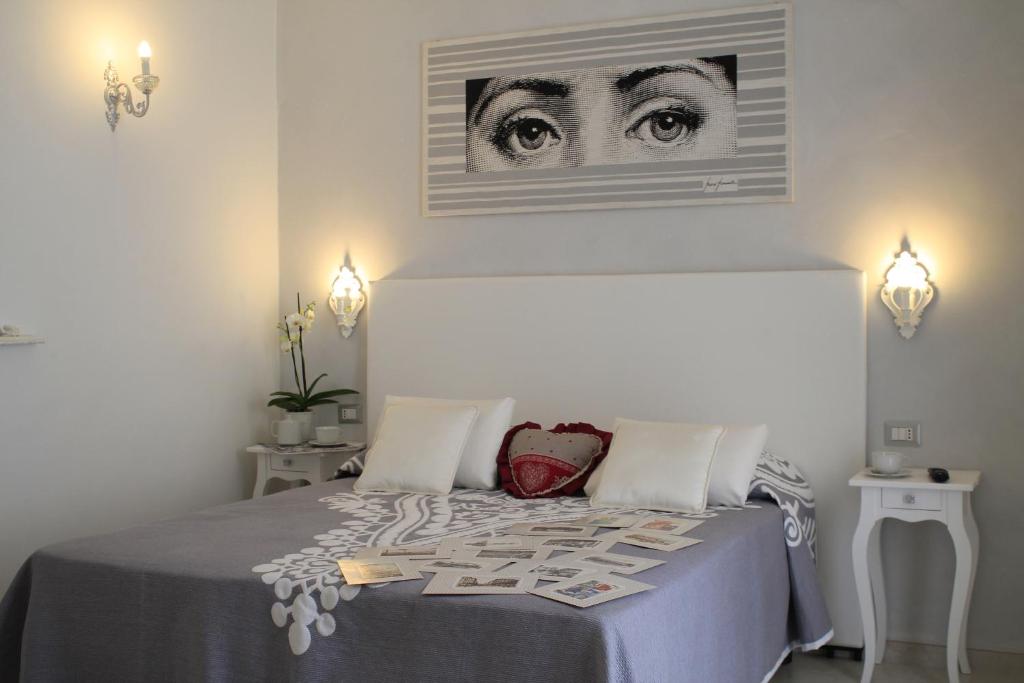 1 dormitorio con 1 cama con una foto de ojos en la pared en Affittacamere Golfo Della Luna, en La Spezia