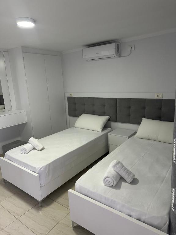 twee bedden in een slaapkamer met handdoeken erop bij Villa Kevin's in Sarandë