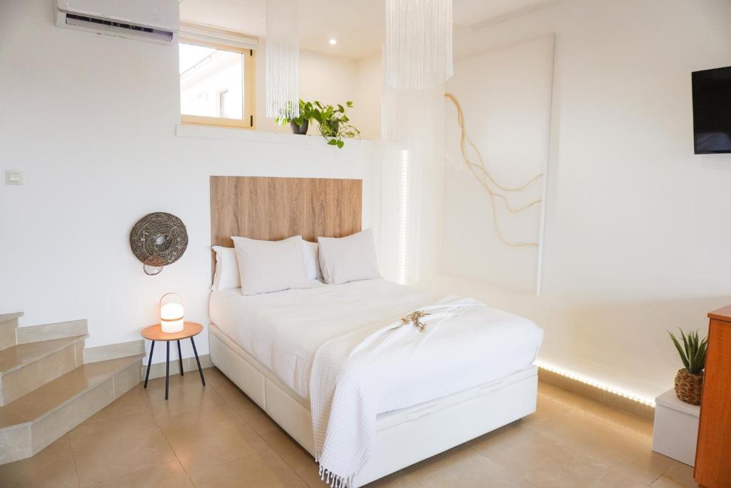 a white bedroom with a white bed and a window at Costa Brava acollidor apartament amb gran terrassa per a 3 persones in Castelló d'Empúries