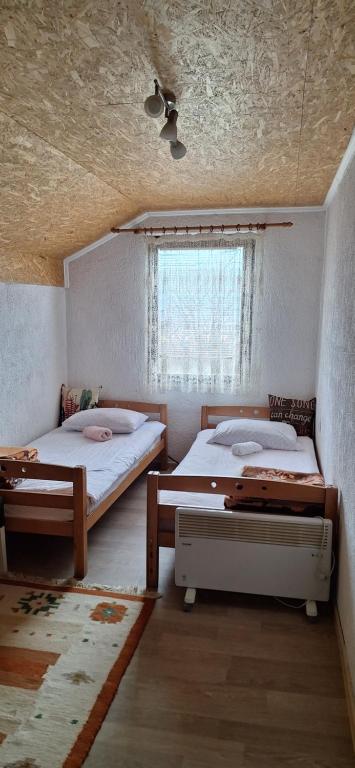 a bedroom with two beds and a window at Medena oaza mira 2 in Visoko