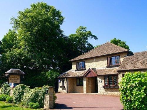 uma grande casa de tijolos com uma placa em frente em Cotswold House em Oxford