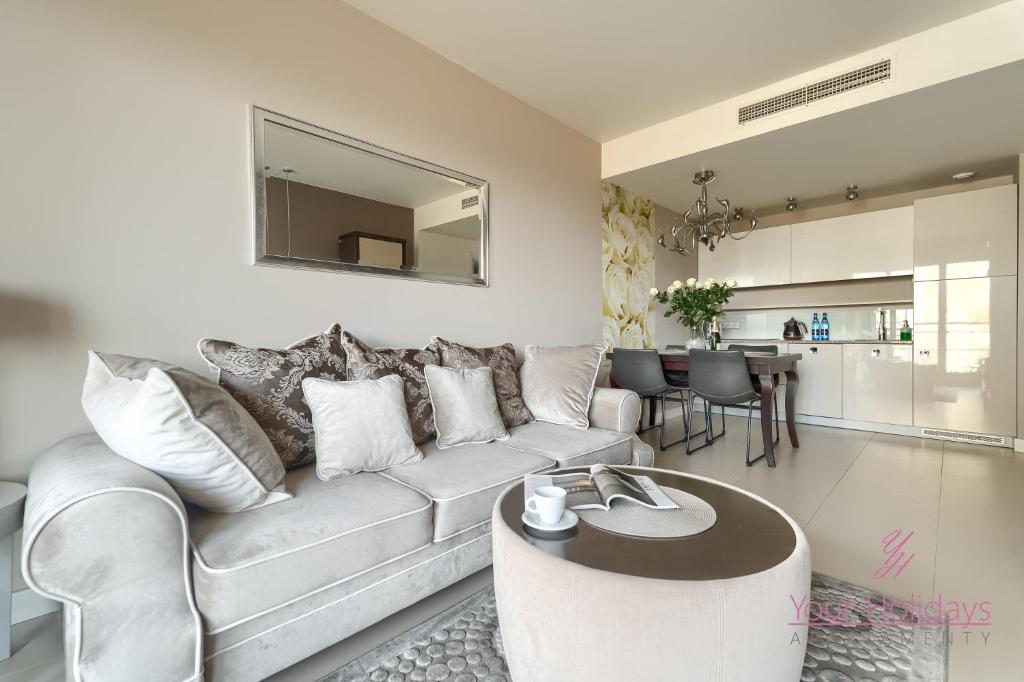 un soggiorno con un divano e un tavolo di Your Holidays Promenada Gwiazd 28 a Międzyzdroje