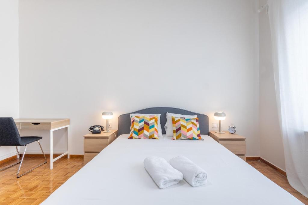 ein Schlafzimmer mit einem großen weißen Bett mit zwei Kissen in der Unterkunft Kipstay Apartments in Athen