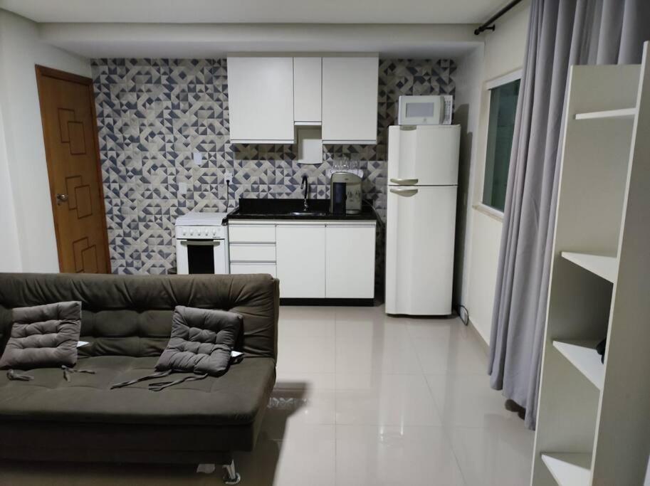 Apartamento encantador 1 Quarto na Candangolândia في برازيليا: غرفة معيشة مع أريكة ومطبخ