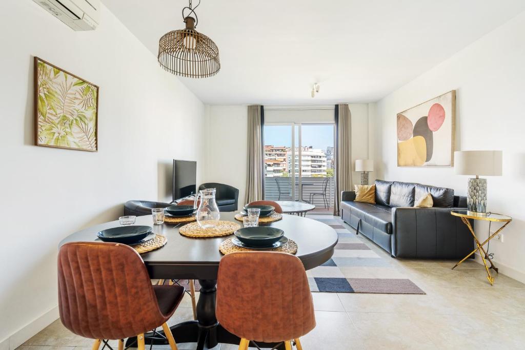 een woonkamer met een tafel en stoelen en een bank bij AB Beach Poble Nou in Barcelona