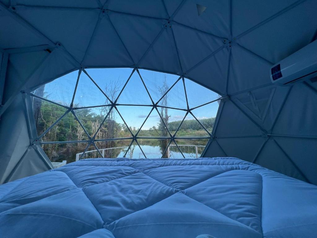 una camera con un letto in una cupola con finestra di Pang Long Chao resort a Trang