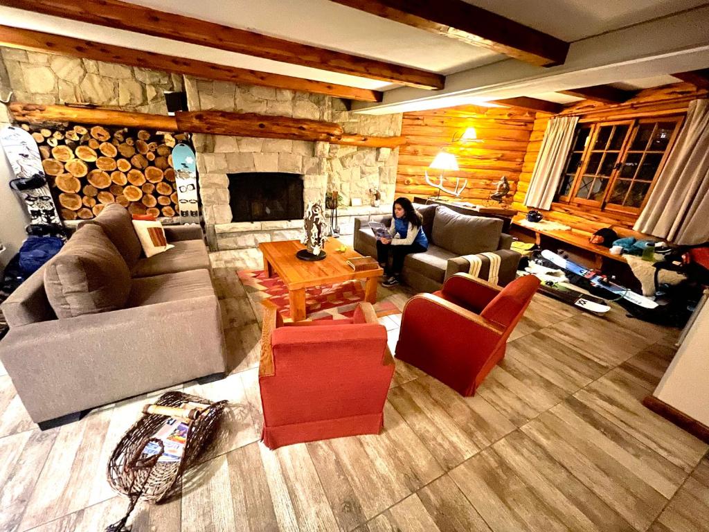 uma mulher sentada numa sala de estar com lareira em Las Marianas Hotel em San Carlos de Bariloche