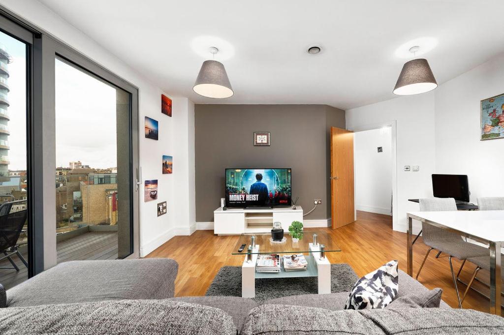 a living room with a couch and a tv at Modern Serviced 3-bedroom flat in East London in London