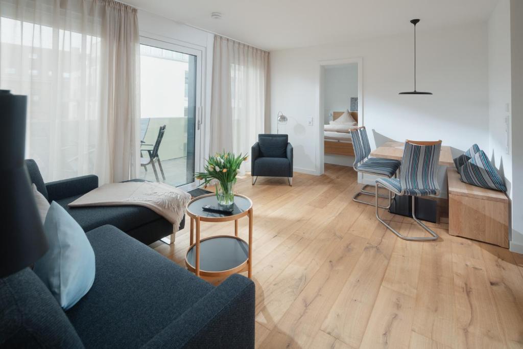 uma sala de estar com um sofá, cadeiras e uma mesa em die ELF em Norderney