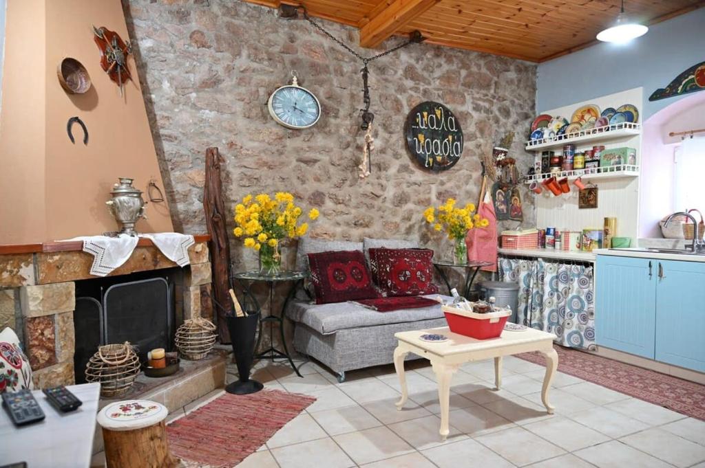 a living room with a couch and a stone wall at Kalavrita Winter Retreat - Homely Spacious Chalet in Áno Vlasía