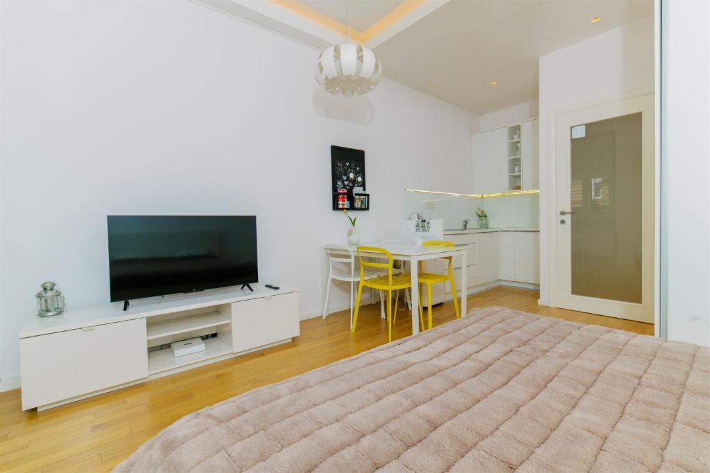 a living room with a bed and a tv and a table at Tia Studio in Zagreb