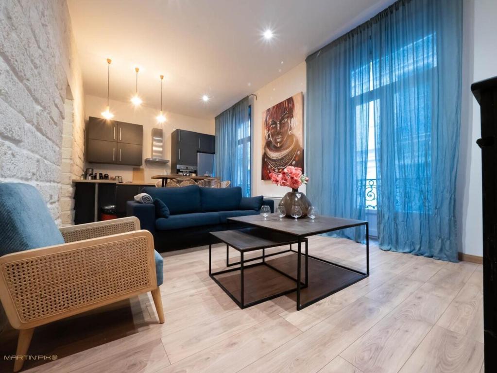 salon z niebieską kanapą i stołem w obiekcie Le passage - Centre ville w Montpellier