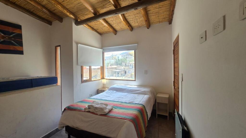 a small bedroom with a bed and a window at El cielo en Purmamarca Duplex 3 in Purmamarca