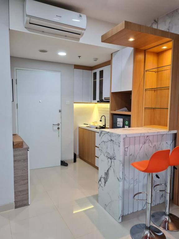 a kitchen with a counter and a red stool at THE NOVE NUVASA KALANI TOWER in Nongsa