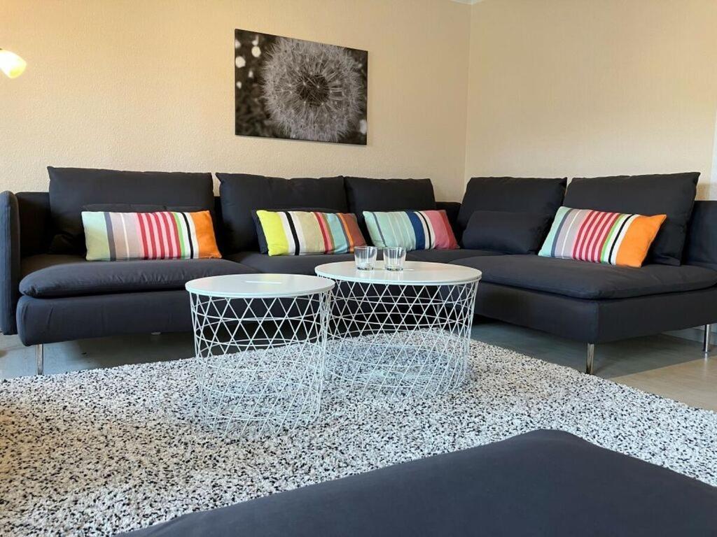 ein Wohnzimmer mit einem blauen Sofa und 2 Tischen in der Unterkunft Apartment in Thuringia in Rettenberg