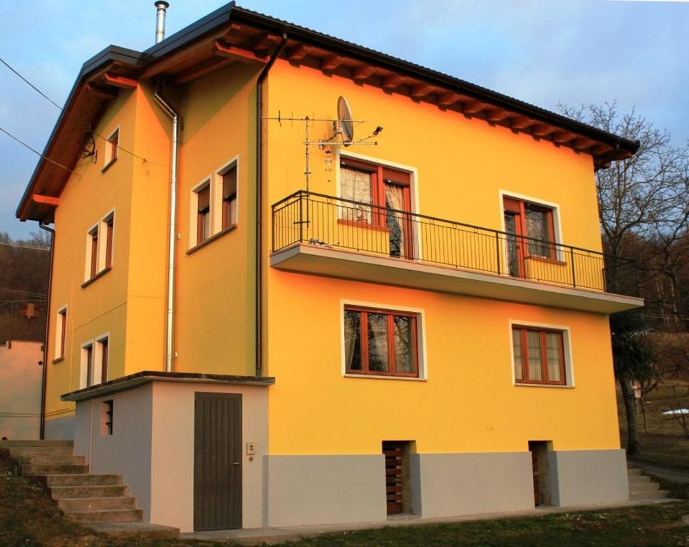 a yellow and white house with a balcony at Discover Italy in Tignes