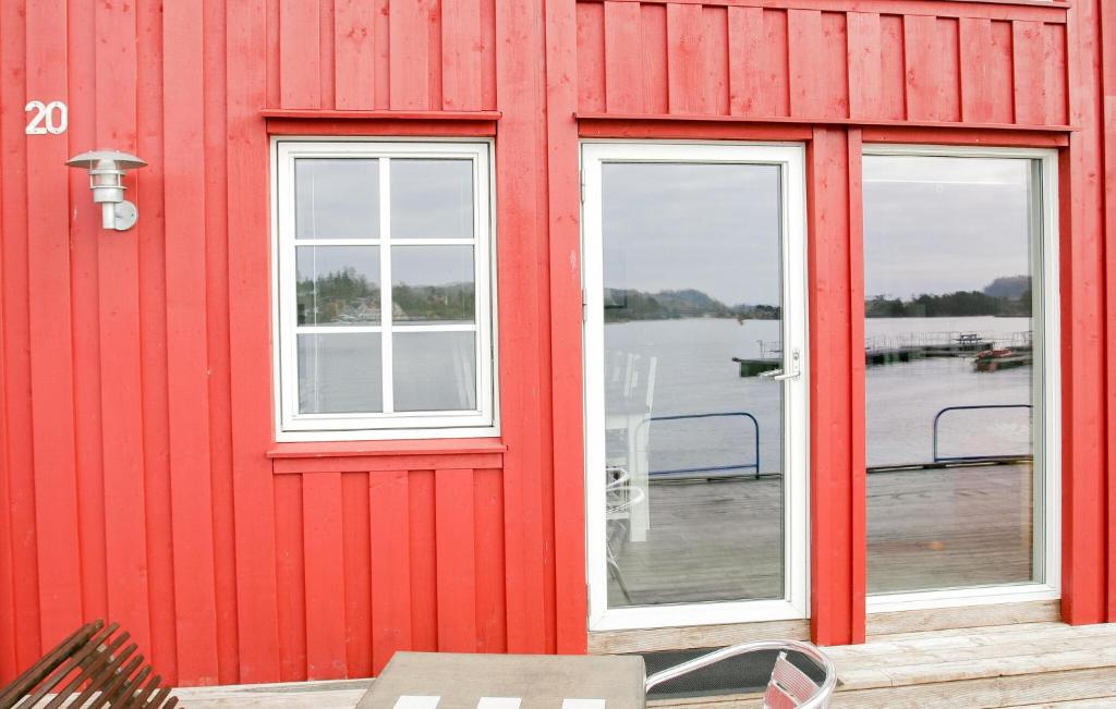 un edificio rojo con dos ventanas y un muelle en Stunning Home In Sjernary With Kitchen, en Sjernarøy