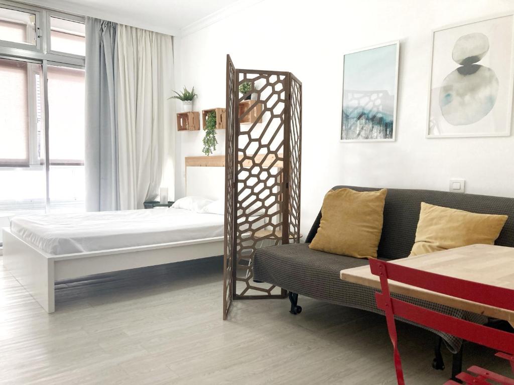 ラスパルマス・デ・グランカナリアにあるLas Canteras Sea II by Canary365のベッド2台とソファが備わる客室です。