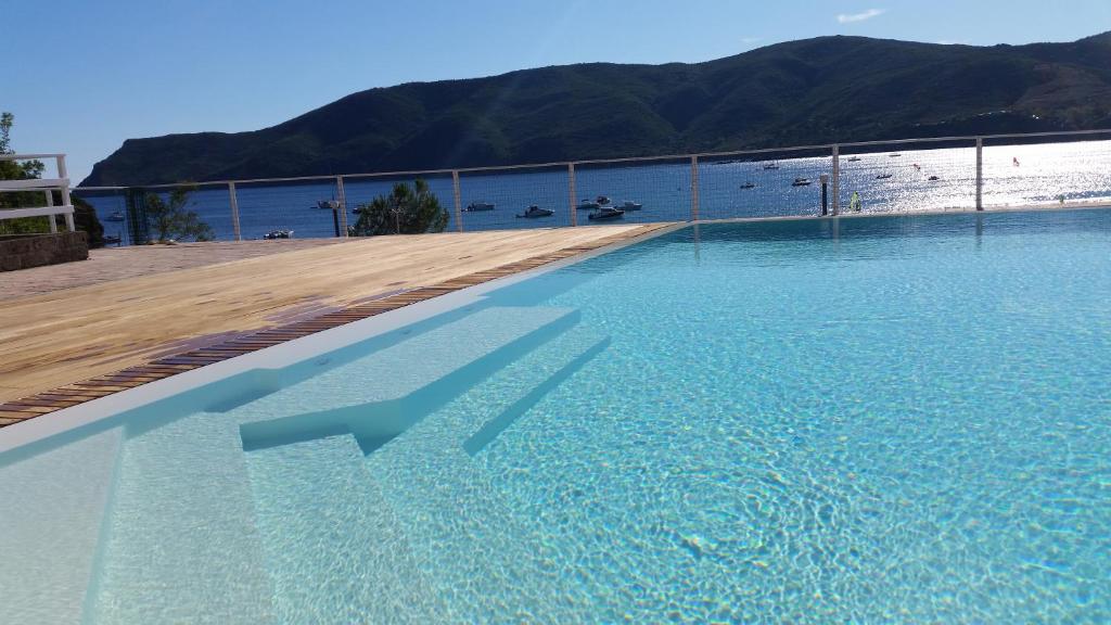 a swimming pool with a view of the beach at Camping Village Stella Mare in Lacona