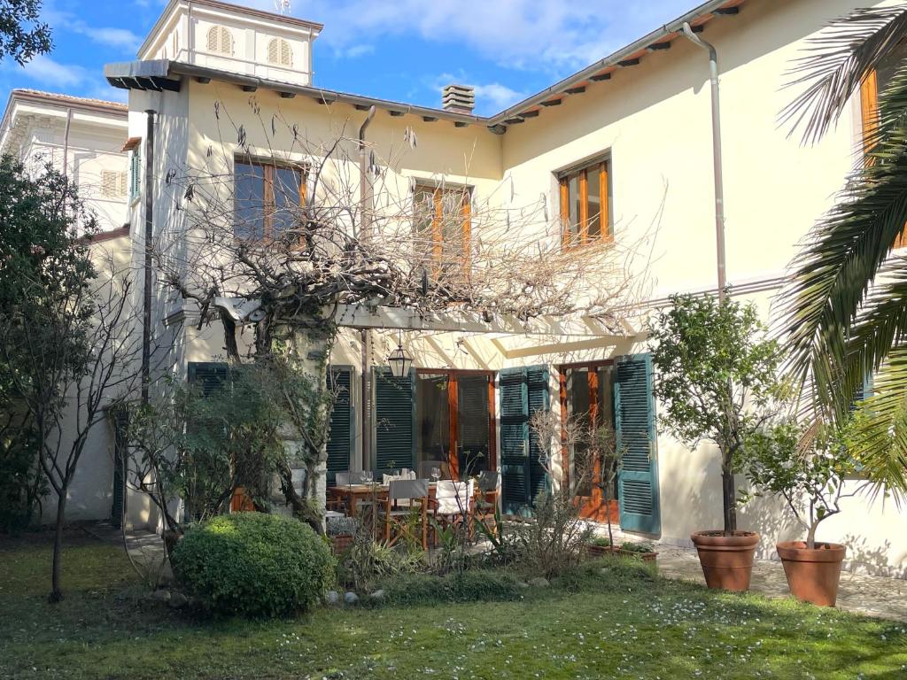 Casa blanca con persianas verdes y patio en Villa Giardino, en Forte dei Marmi