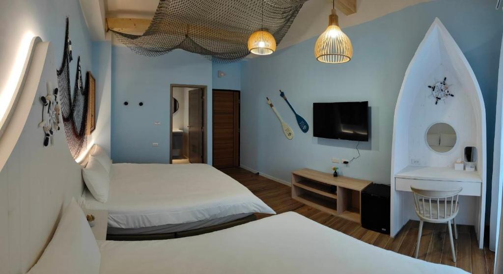 Habitación de hotel con 2 camas y TV en Mi Hai B&B, en Magong