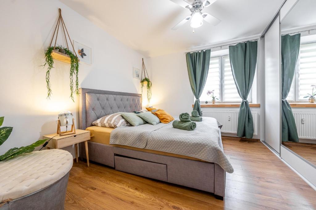 a bedroom with a bed with green curtains at Tatra Apartment Košice Center in Košice