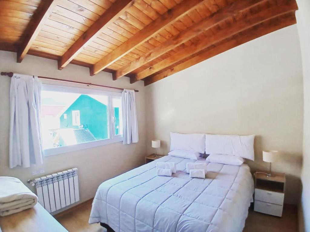 a bedroom with a large bed and a window at Aparts Merkaba in El Chalten