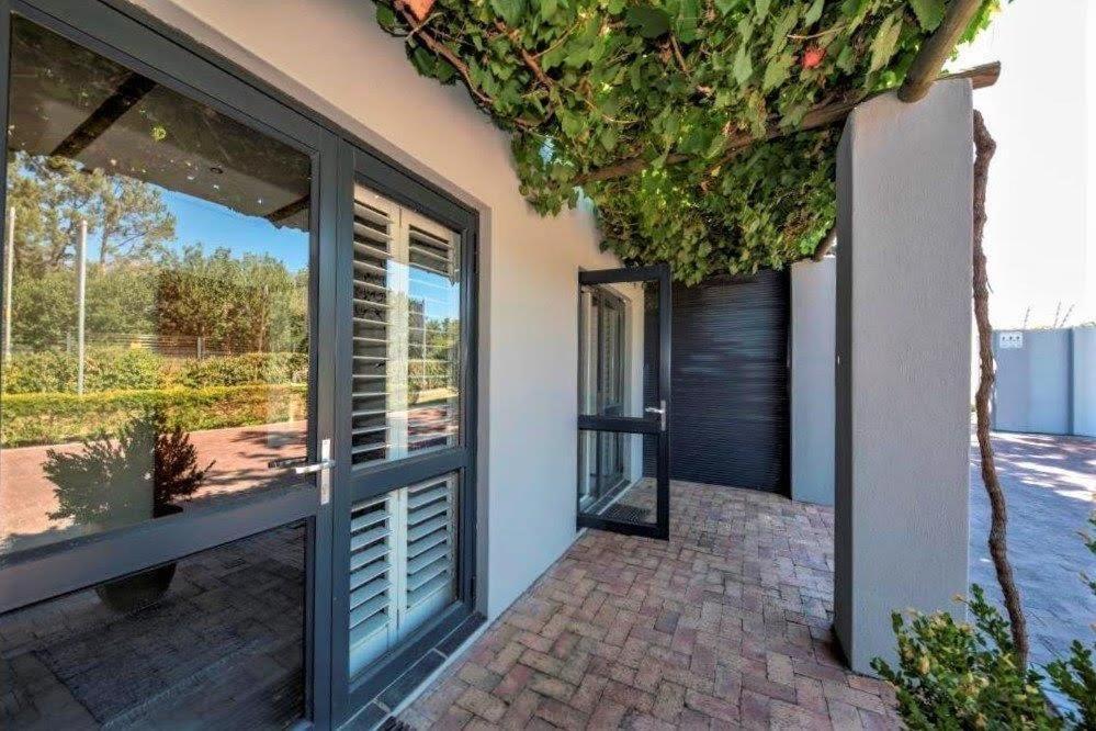 a glass door of a house with a patio at Wine Route Cottages in Simondium