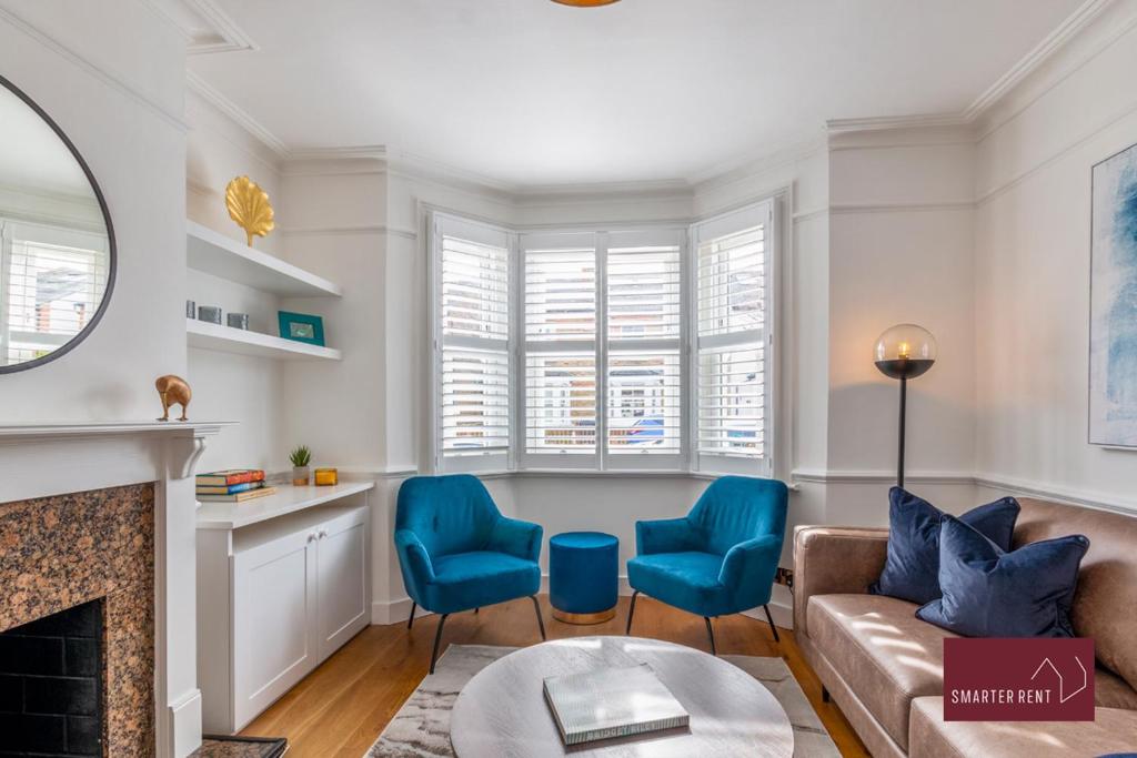 a living room with a couch and two blue chairs at 3 Bed Victorian House - Kingston On Thames in Kingston upon Thames