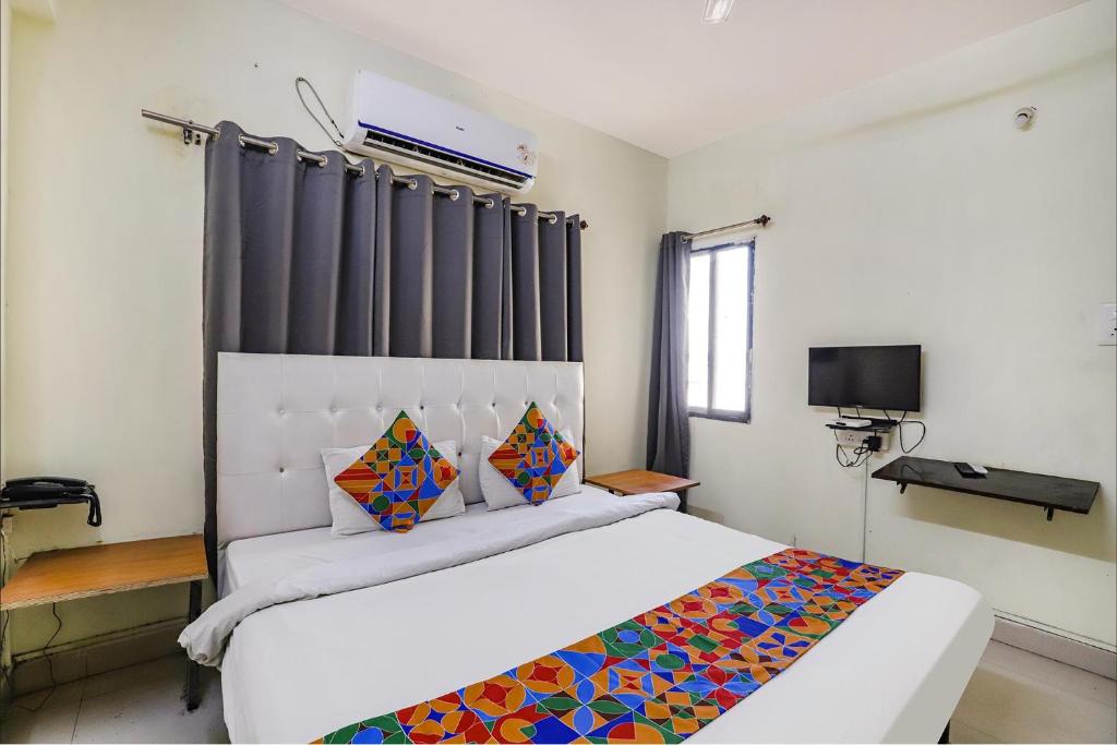 een slaapkamer met een groot wit bed en een raam bij FabExpress Osca Inn in Nagpur