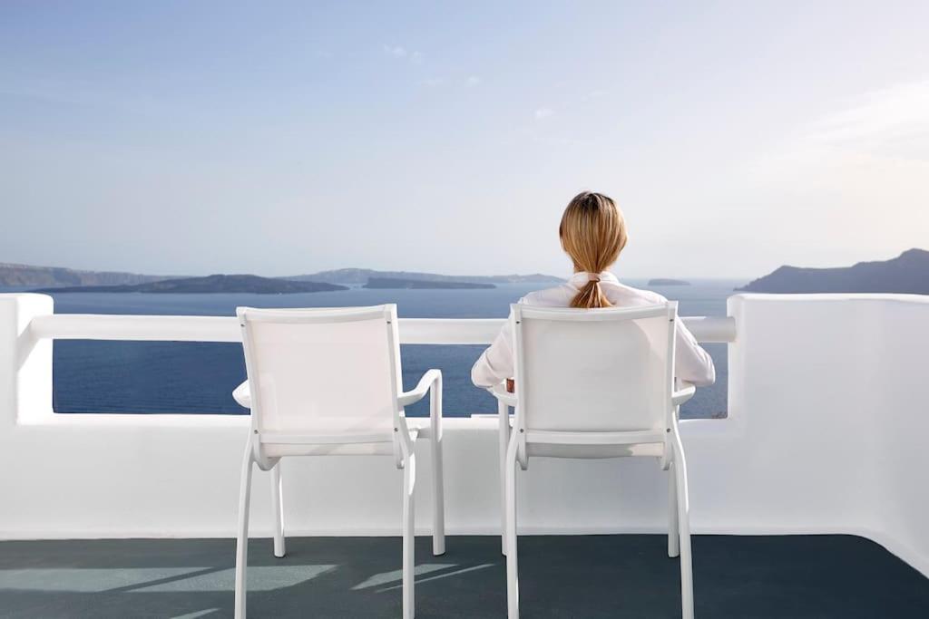 une femme assise sur une chaise donnant sur l'océan dans l'établissement DAY DREAM 2, à Oia
