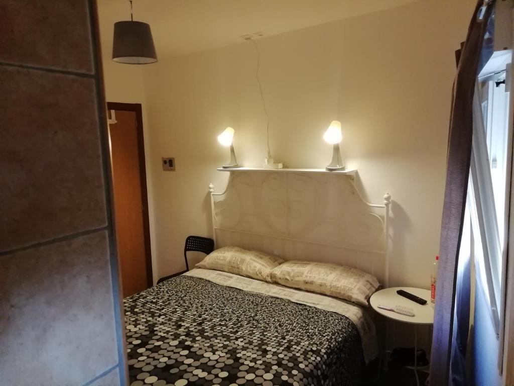 拉古納的住宿－MasRelaxTenerife，卧室配有一张带两盏灯的墙壁床。