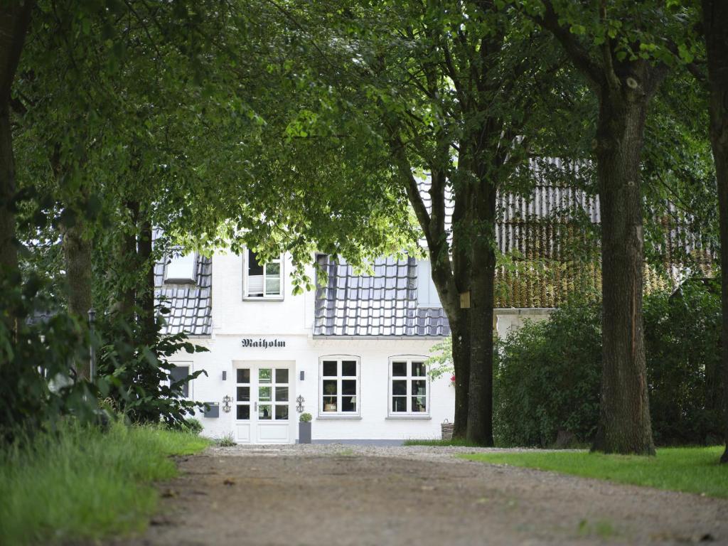 a white house with trees in front of it at Hof Maiholm - Sattelkammer in Medelby