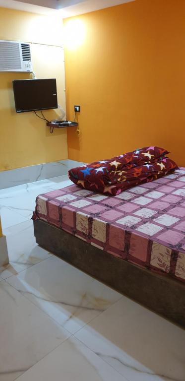 een slaapkamer met een bed met een paars dekbed bij Hotel Eleven in Bhagalpur