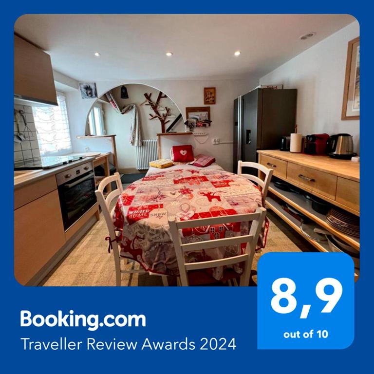 - une cuisine avec une table et une nappe rouge dans l'établissement Charmant gîte au coeur du Centre Ville, à Gérardmer