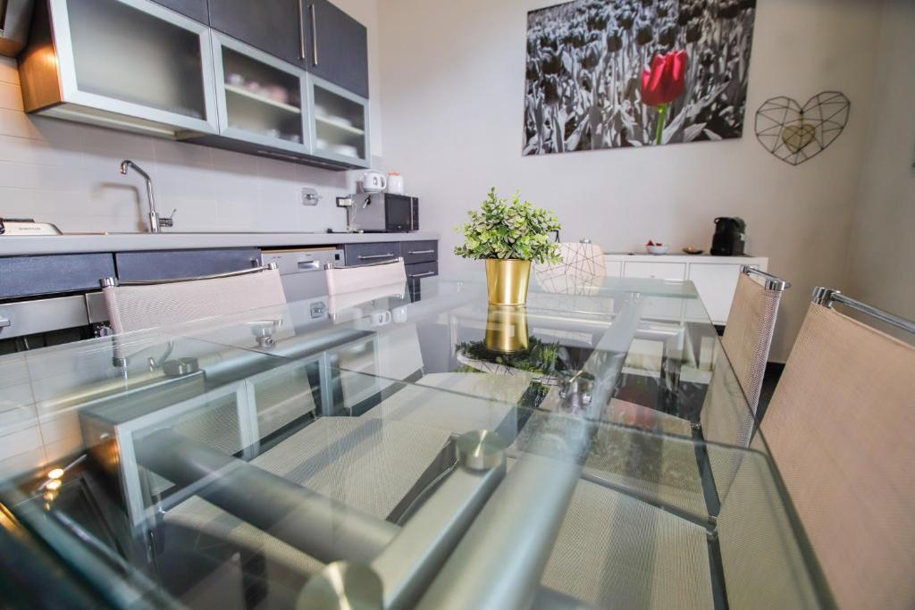 einen Esstisch aus Glas in einer Küche mit Stühlen in der Unterkunft Appartamento Casa Nizza - Metro Lingotto fiere by Bib's Apartments in Turin