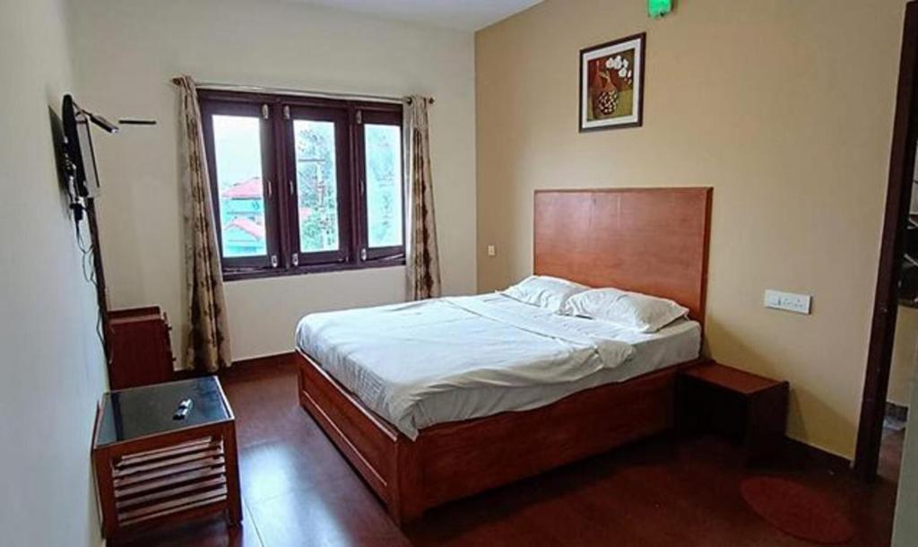 um quarto com uma cama grande e uma janela em FabHotel Sri Guhan EIite em Kodaikānāl