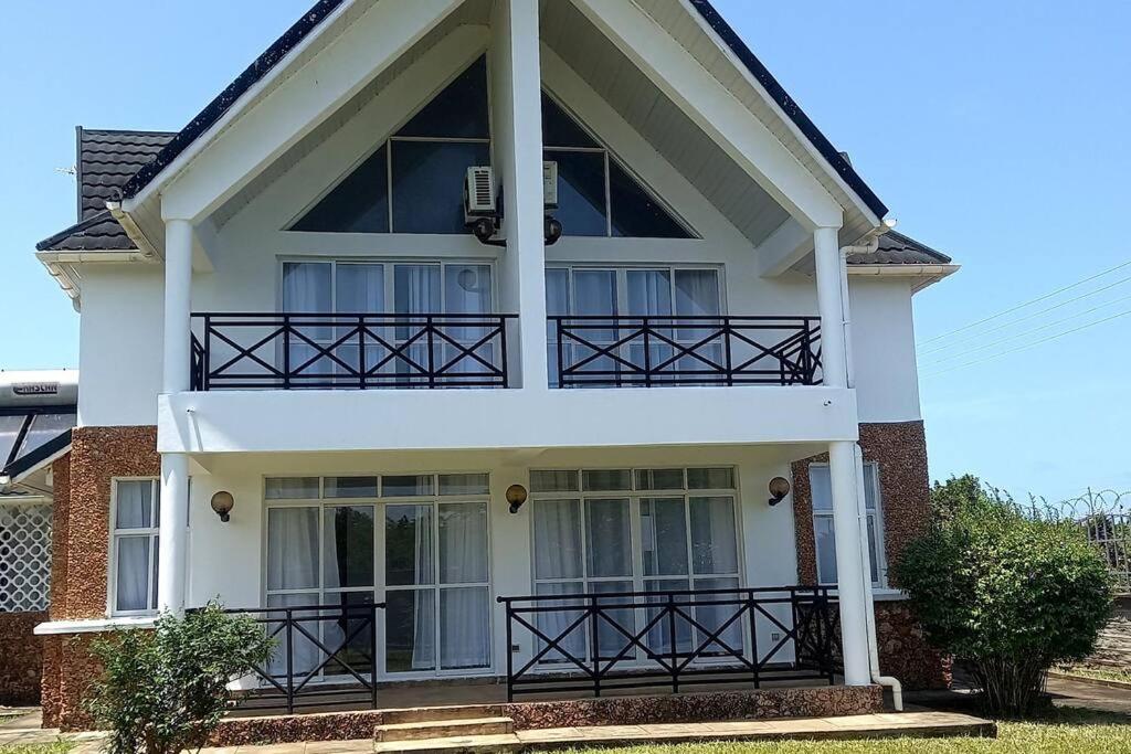 uma casa com uma varanda em cima em Blue Waters Villas em Ukunda