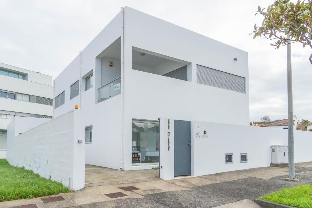 un edificio blanco angular con una gran puerta en Casa verde, en Ribeira Grande