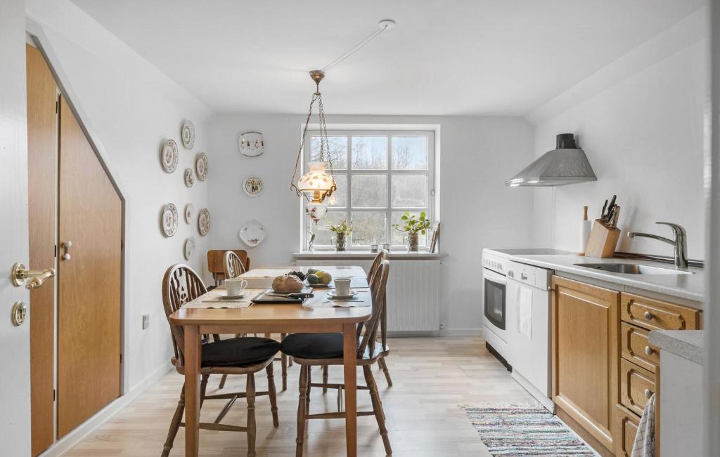 a kitchen with a table and chairs and a window at 3 Bedroom Lovely Apartment In Engesvang in Engesvang