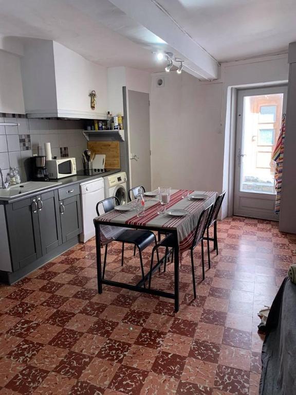 une cuisine avec une table et des chaises dans une pièce dans l'établissement 5RBUT1 - Maison familiale sur deux niveaux en plein coeur du centre ville, à Collioure