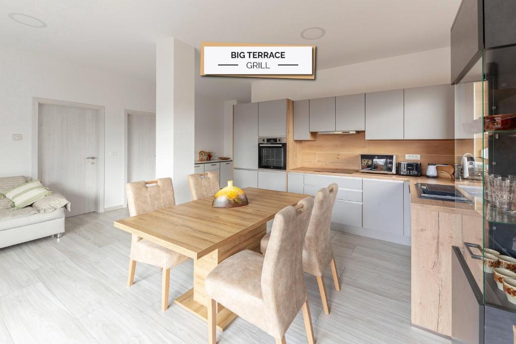 a kitchen and dining room with a wooden table and chairs at Apartma Žan in Šmarje