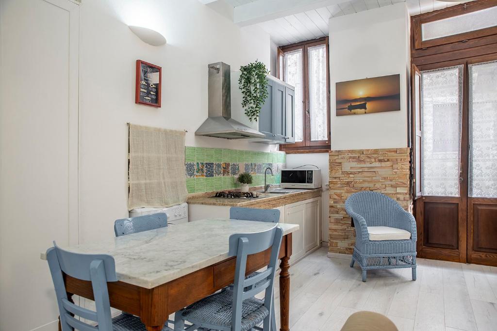 a kitchen with a table and chairs in a room at Appartamento a Ortigia in Syracuse