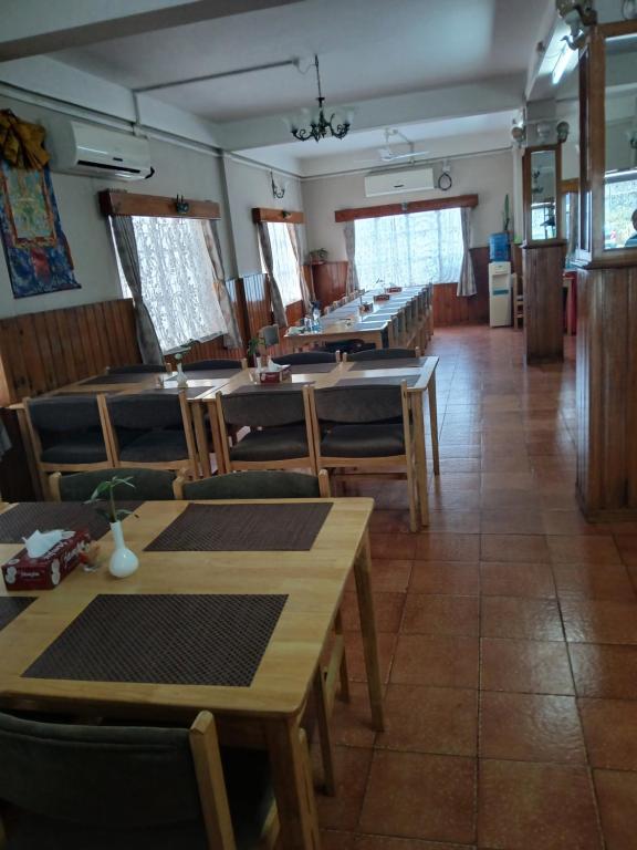 a dining room with wooden tables and chairs at Tashi Yarphel in Pajo