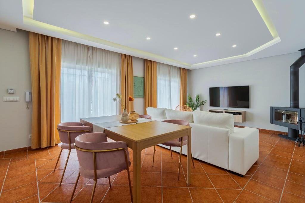 a living room with a white couch and a table at Casa Rosa in Quinta do Conde