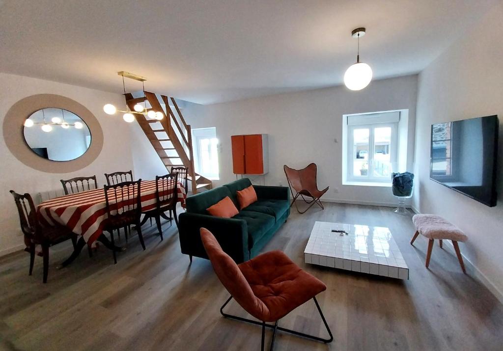 un salon avec un canapé vert et une salle à manger dans l'établissement Appartement cosy chic La Ville au Monnier, à Pleurtuit