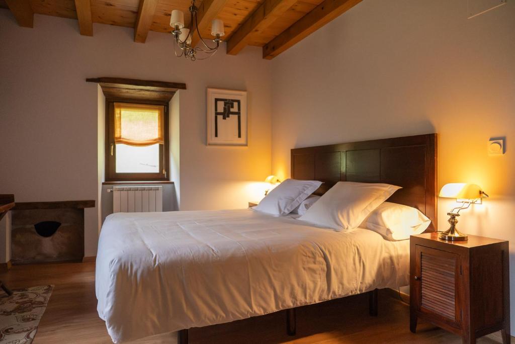 a bedroom with a large white bed and a window at Olagaraia - Adults Only in Etxalar