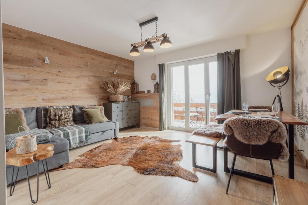 ein Wohnzimmer mit einem Sofa und einem Tisch in der Unterkunft Magnifique appartement avec vue sur les montagnes in Crans-Montana