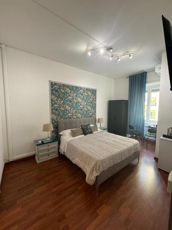 a bedroom with a bed and a painting on the wall at Room Sapienza in Rome